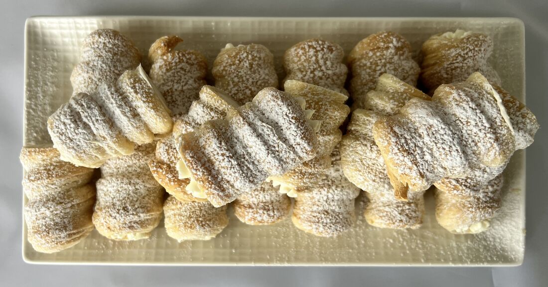 Box of twenty mini PastryVille cream rolls, dusted with powdered sugar